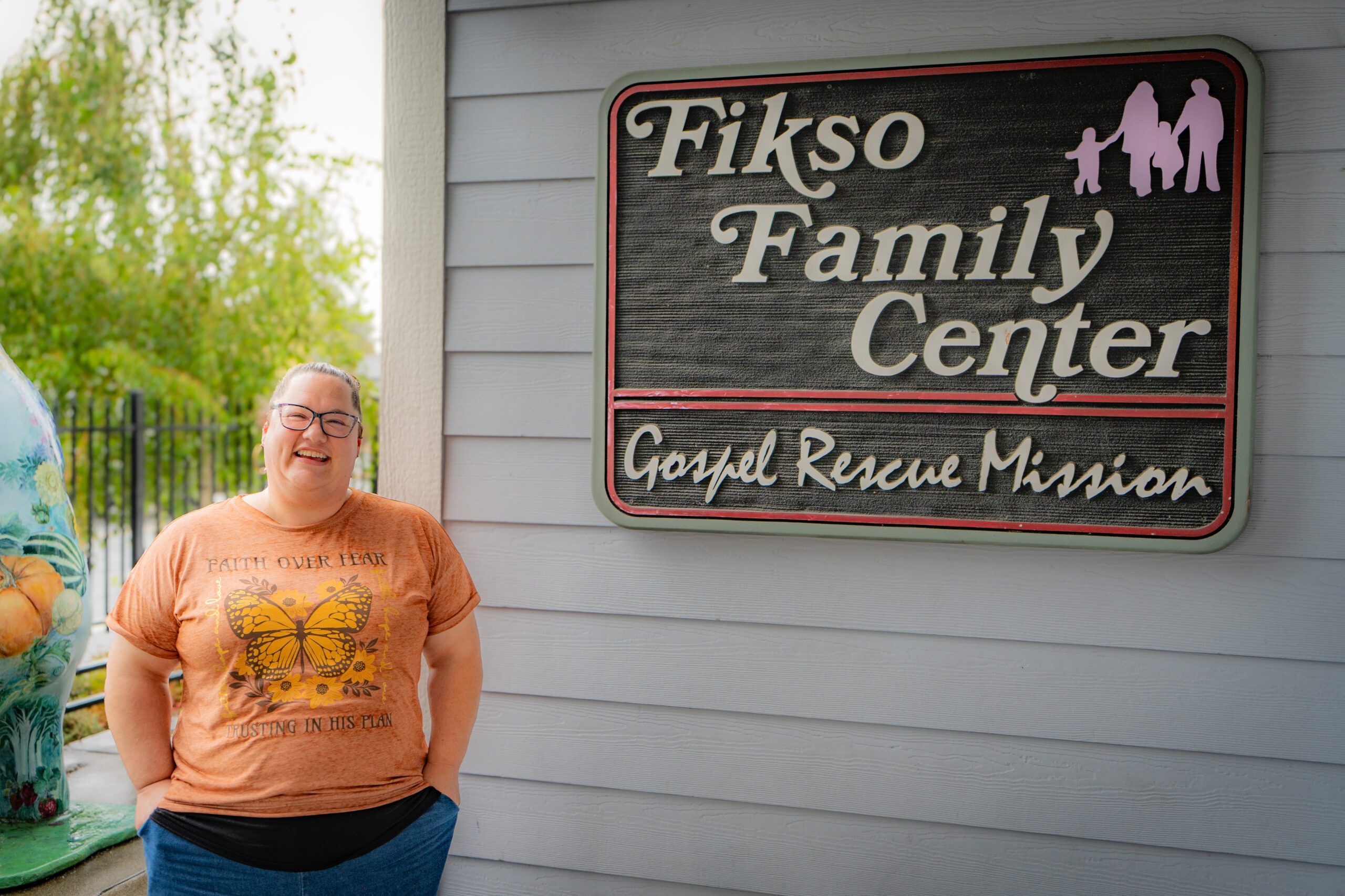Christine standing by the Fikso Family Center sign.